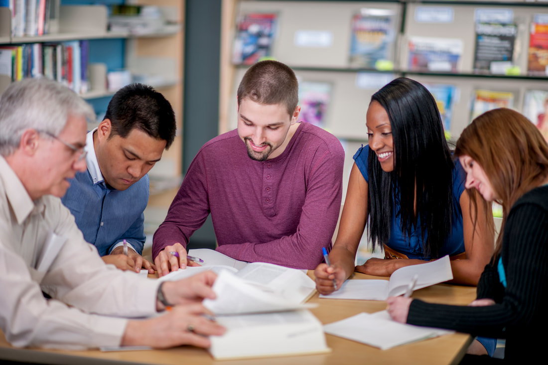 Group of diverse people writing at a table together