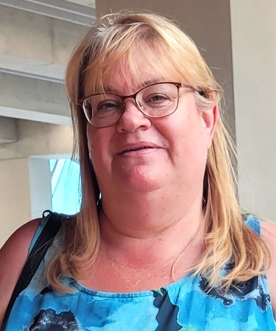Blond haired caucasian women in blue dress witih glasses