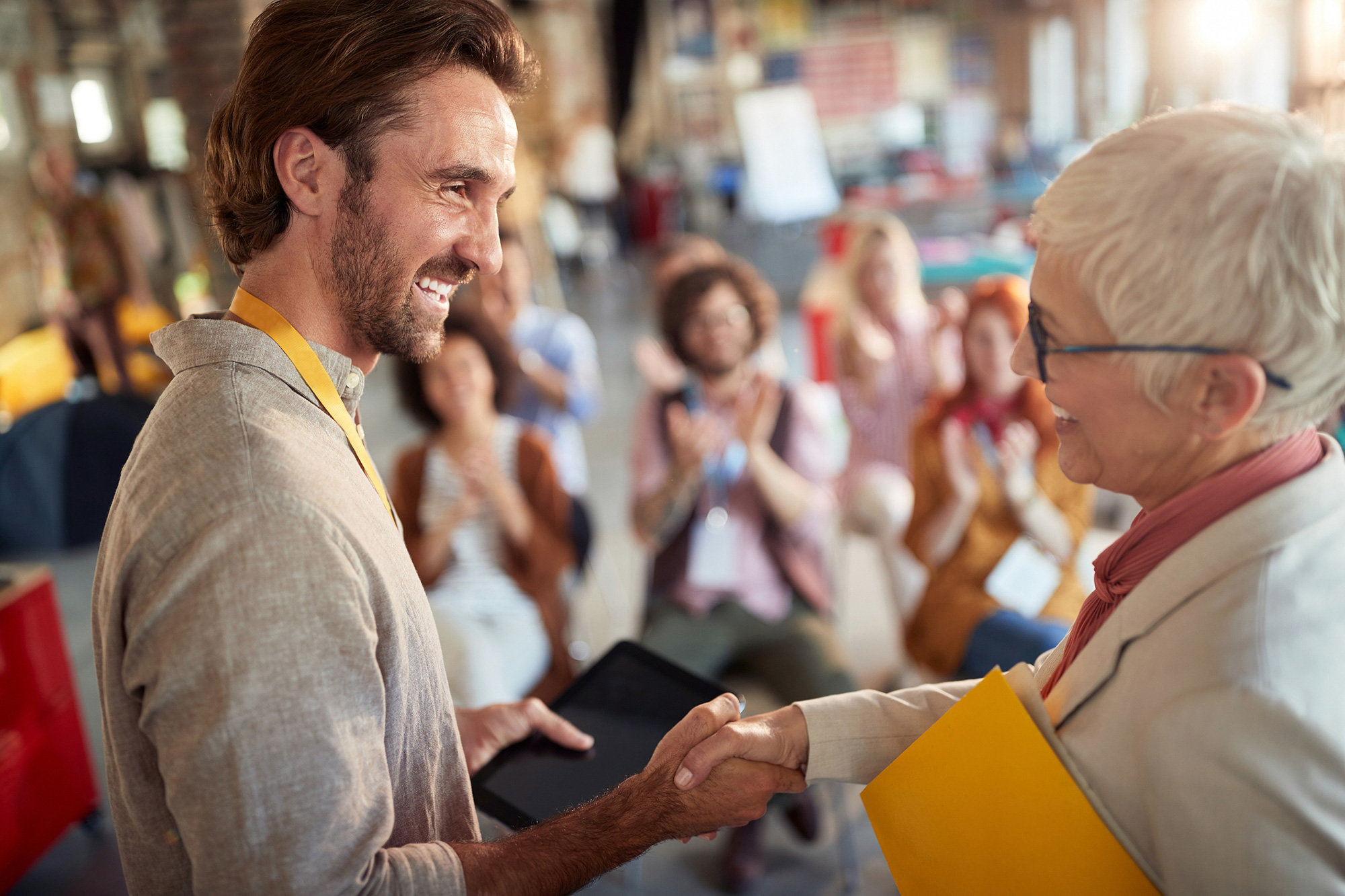 young man shaking hands with an senior woman